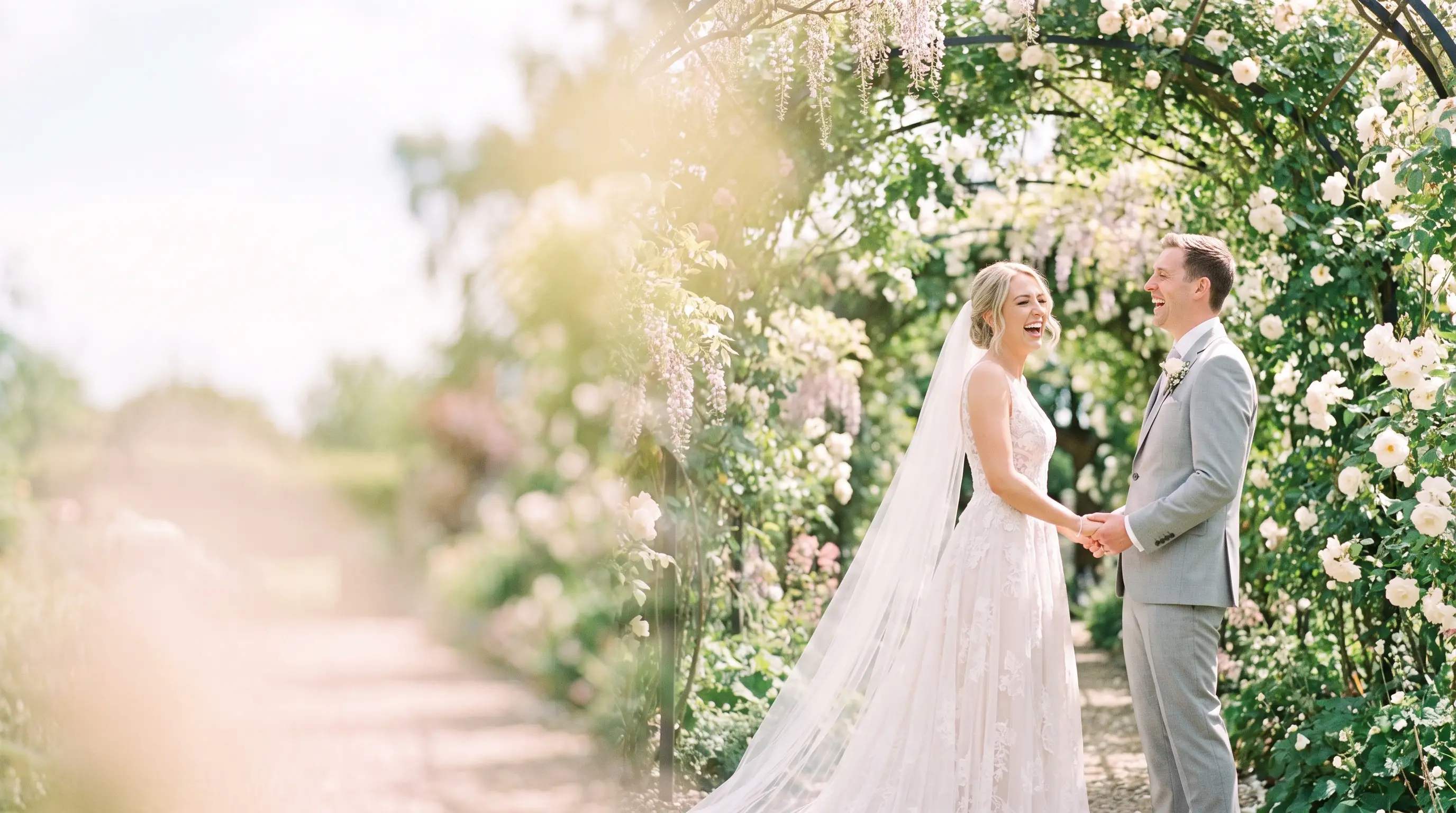 Bride and groom laughing in a sunlit garden